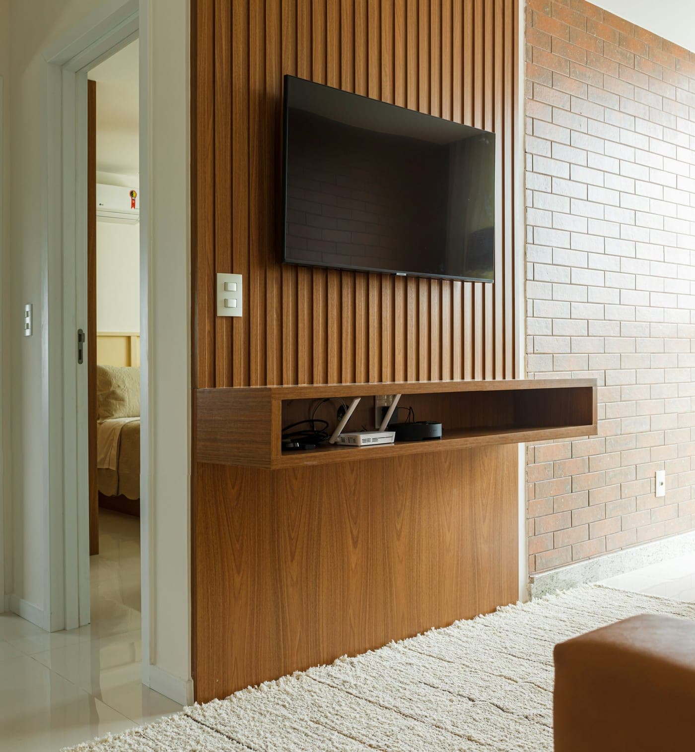 Sala com painel ripado de madeira e rack planejado